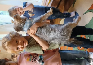 chłopiec trzyma psa na rękach